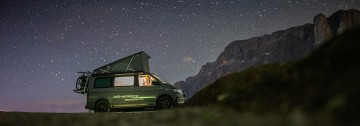 VW Nutzfahrzeug Bulli California mit Aufstelldach draußen in der Natur in der Nacht