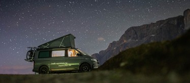 VW Nutzfahrzeug Bulli California mit Aufstelldach draußen in der Natur in der Nacht